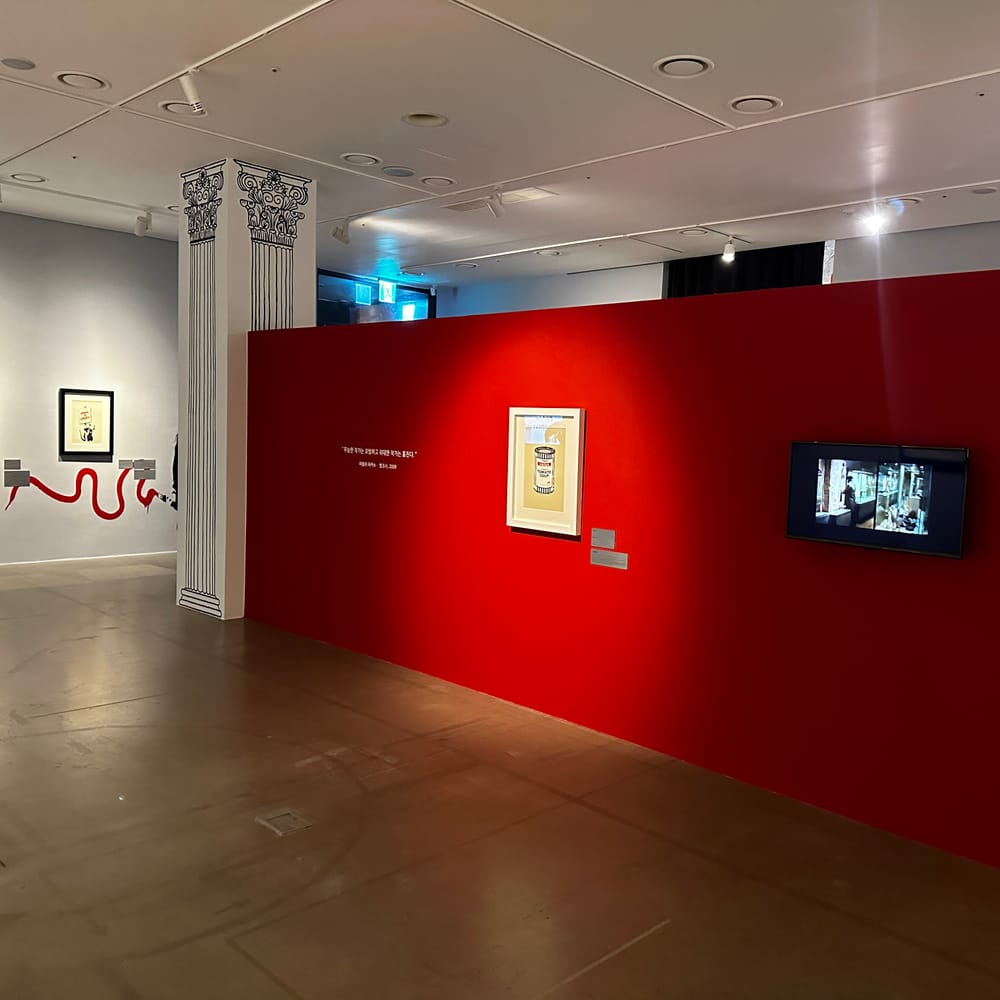Red-walled gallery in the Real Banksy exhibition